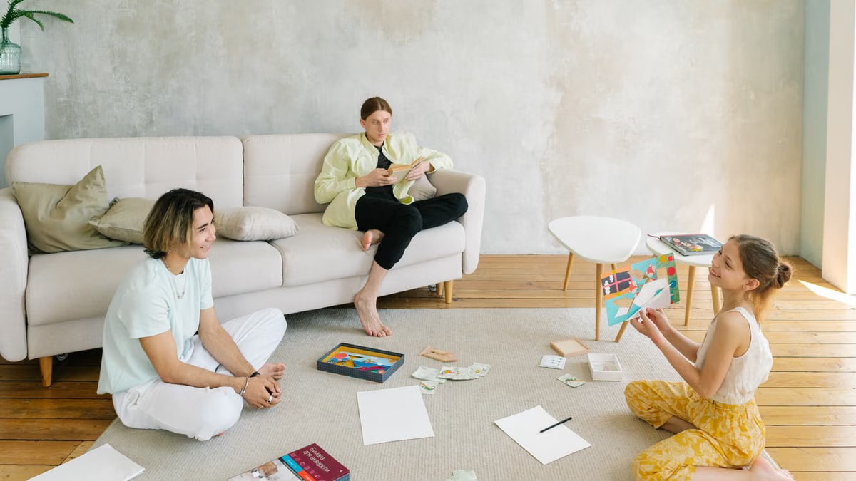 A family enjoying creative activities together in a bright living room setting.